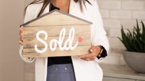 lady holding a sell sign